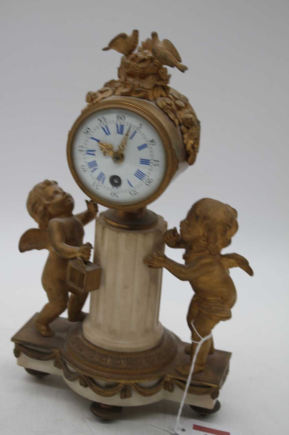 A 19th century French gilt metal figural mantel clock, the enamel dial showing Roman numerals,