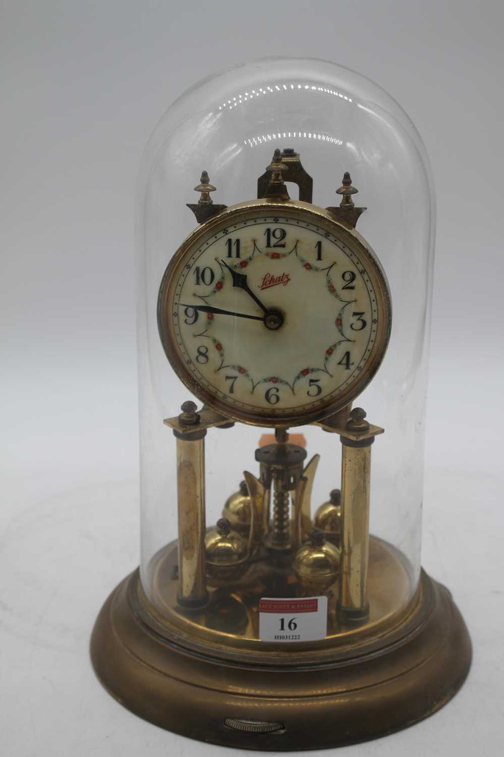 A Schatz brass anniversary clock, housed under a glass dome, height 29cm