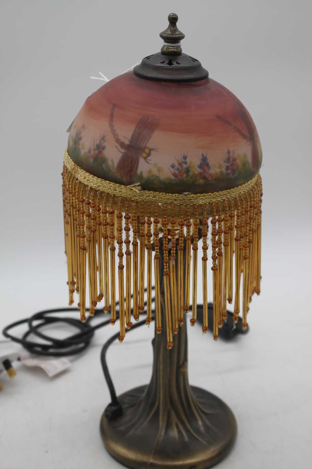 A Tiffany style table lamp, having a glass shade decorated with dragonflies amongst flowers,