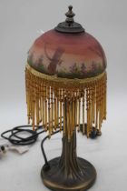 A Tiffany style table lamp, having a glass shade decorated with dragonflies amongst flowers,