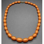 A faux amber single string necklace, arranged as graduated barrel beads, 48g