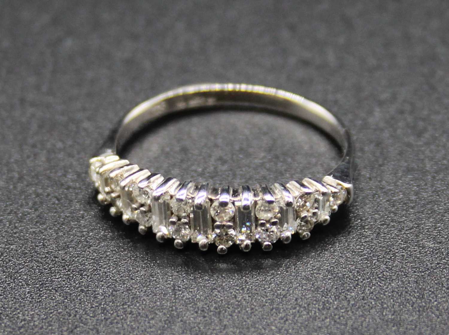 A modern 18ct white gold diamond half hoop ring, arranged as alternating baguettes and twin round