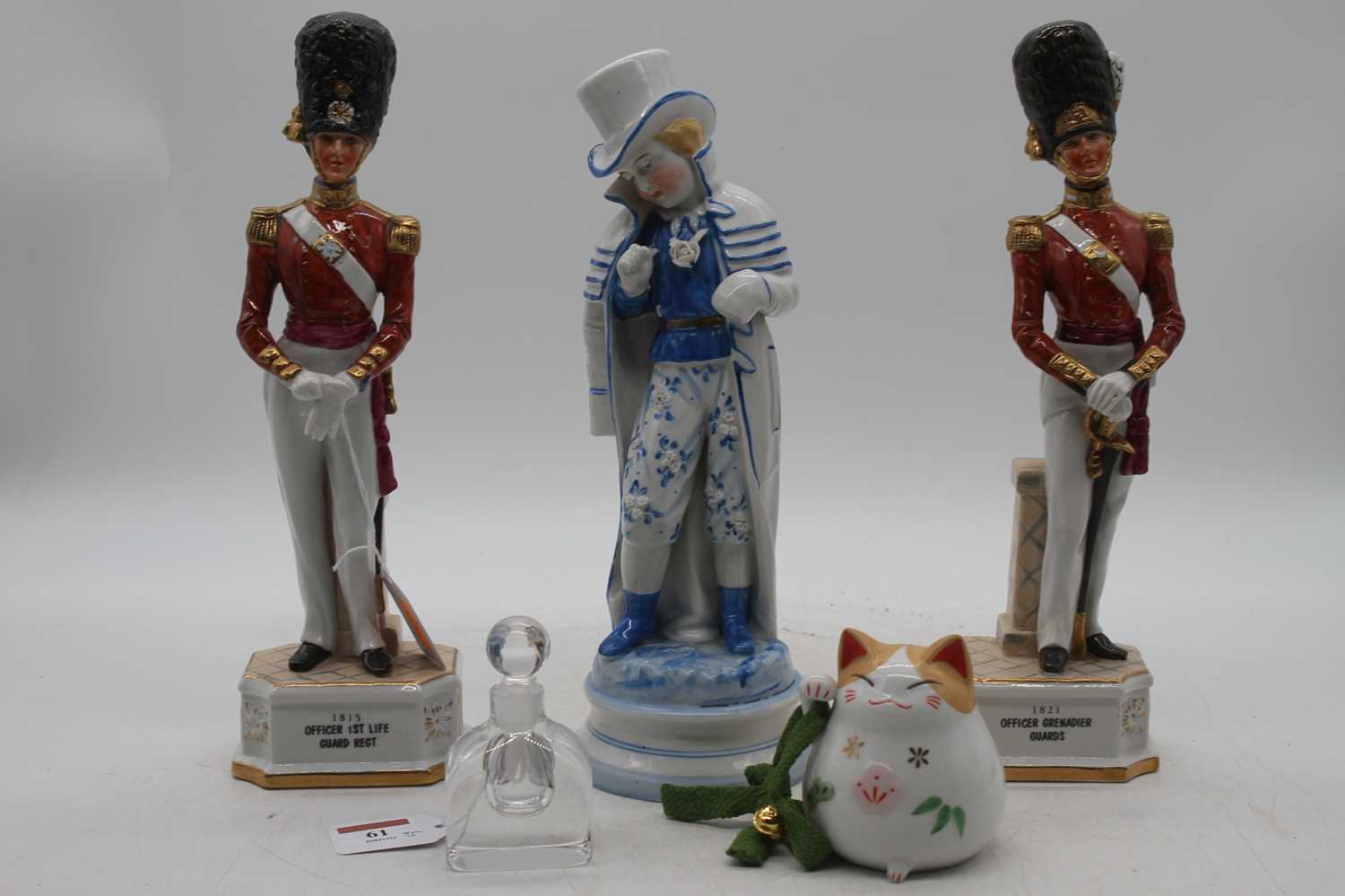 A pair of porcelain figures of soldiers, height 31cm, together with another porcelain figure, a