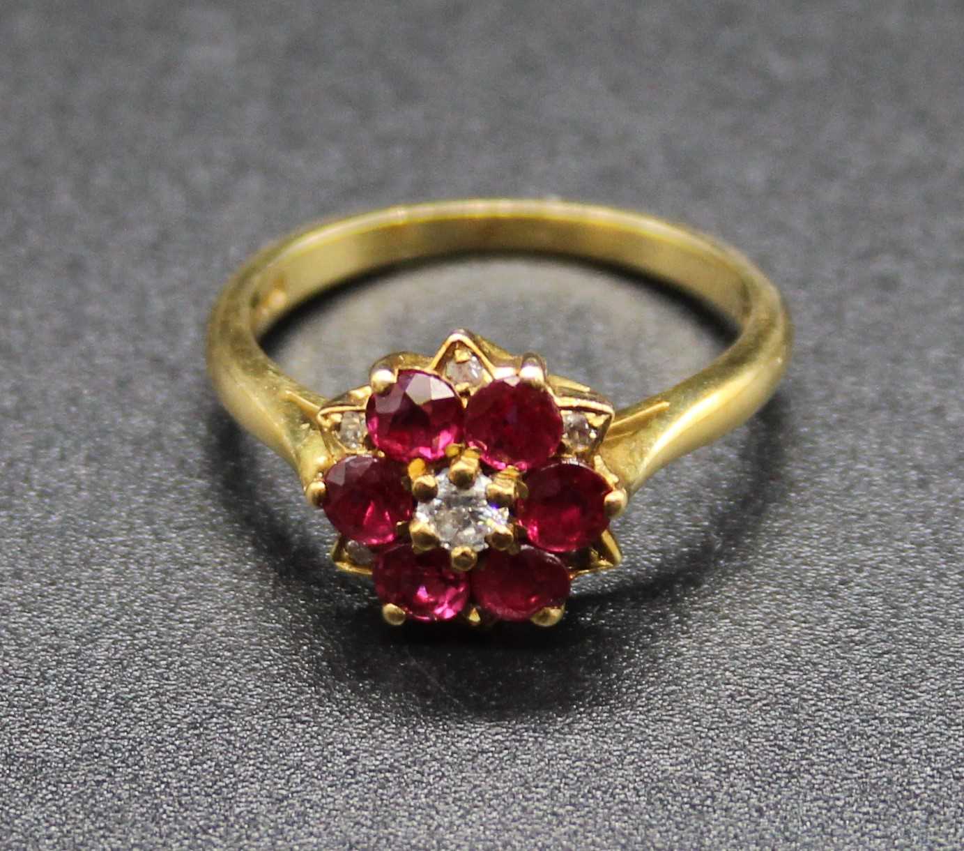 An 18ct gold, ruby and diamond cluster ring (rubies possibly heat-treated), setting dia.10mm, 2.