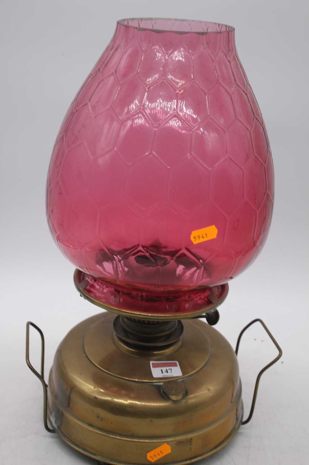 A Victorian brass oil lamp, the large cranberry tinted glass shade above a plain brass font, - Image 2 of 2