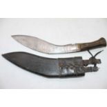 A 20th century kukri having a 31cm curved steel blade with brass mounted horn handle in leather