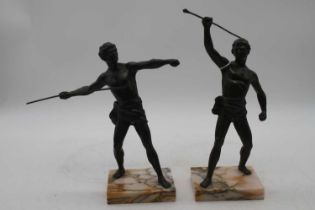 A pair of bronzed figures of athletes, each shown rasing a spear, mounted upon a polished