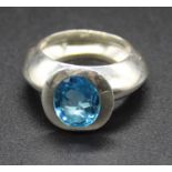 A contemporary silver and blue topaz set dress ring, the oval cut topaz measuring approx 10.5 x 8.