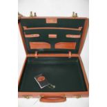 A leather attache case with brass locks, interior label for Papworth Fine Leather Luggage,