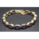 A 9ct gold and amethyst bracelet, arranged as 15 oval cut amethyst to a lobster claw fitting, with