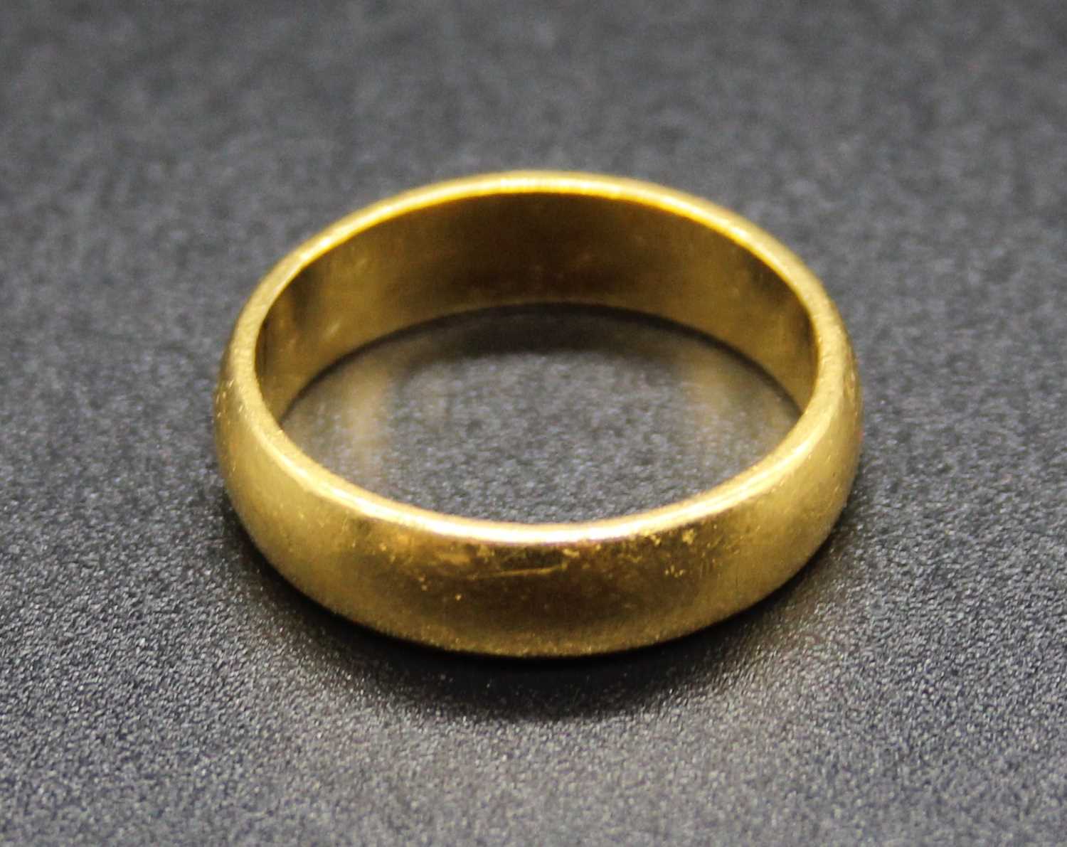 A yellow metal wedding band, stamped 22ct and tests as 22ct gold, 5.7g, size L/M