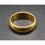A yellow metal wedding band, stamped 22ct and tests as 22ct gold, 5.7g, size L/M