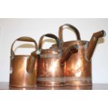 A matched set of three Victorian copper graduated watering cans, largest height 34cm
