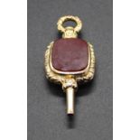 A Victorian style yellow metal and agate set watch key with carved border, unmarked but tests as