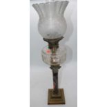 A Victorian brass oil lamp, the acid etched shade above a faceted font and corinthian column stem,