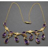 An early 20th century yellow metal, amethyst and seed pearl set necklet, arranged as seven pear