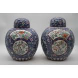 A pair of Chinese export jars and covers, each of globular form, on a blue ground with opposing