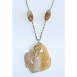 A carved agate pendant with yellow metal sea serpent and attached to a yellow metal Prince of