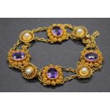 An early 20th century yellow metal, amethyst and seed pearl set sectional bracelet, arranged as