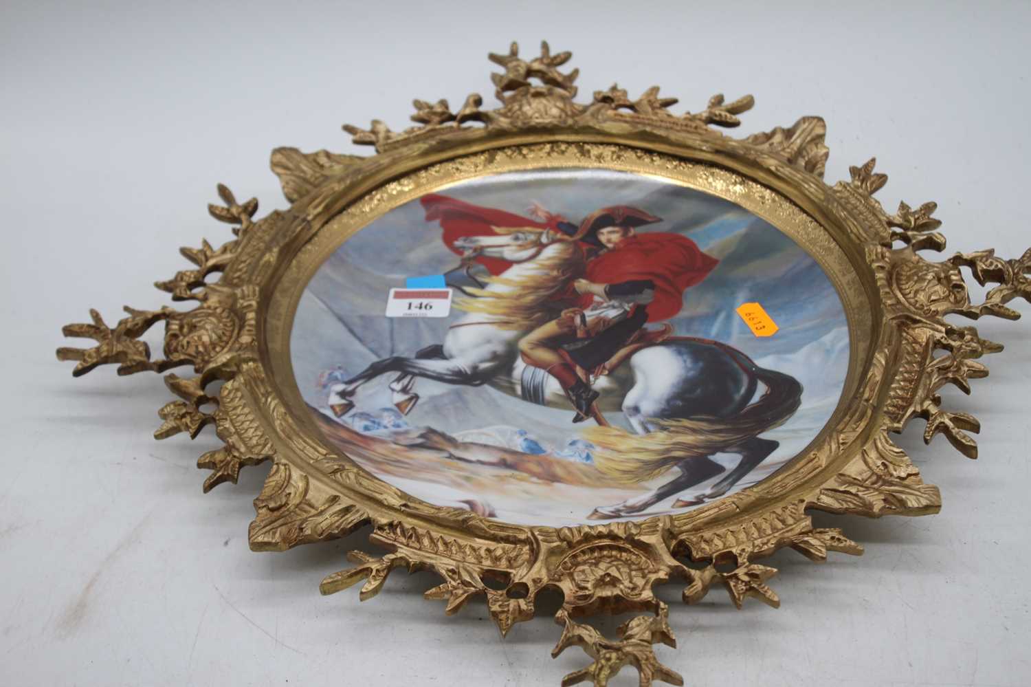 A reproduction porcelain dish, decorated with Napoleon, housed within a gilt metal mount, height