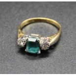 An 18ct gold, green peridot and diamond set dress ring, the four claw set emerald cut peridot