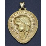 A yellow metal pendant, relief cast with an angel amidst stars, unmarked but tests as approx 18ct,