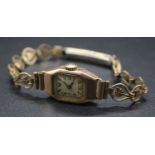A lady's vintage 9ct gold cased Art Deco influenced tank watch, case dia. 15mm, on gilt metal