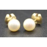 A pair of yellow metal single pearl stud earrings each comprising a 7.1mm cultured Akoya pearl
