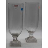 A pair of cut glass hurricane lamps, each on faceted stem and stepped plinth, height 34cm