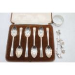 A set of six Elizabeth II silver teaspoons in Harrods of London case together with a white metal
