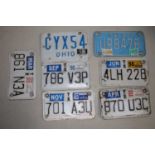 A collection of assorted pressed metal American style numberplates