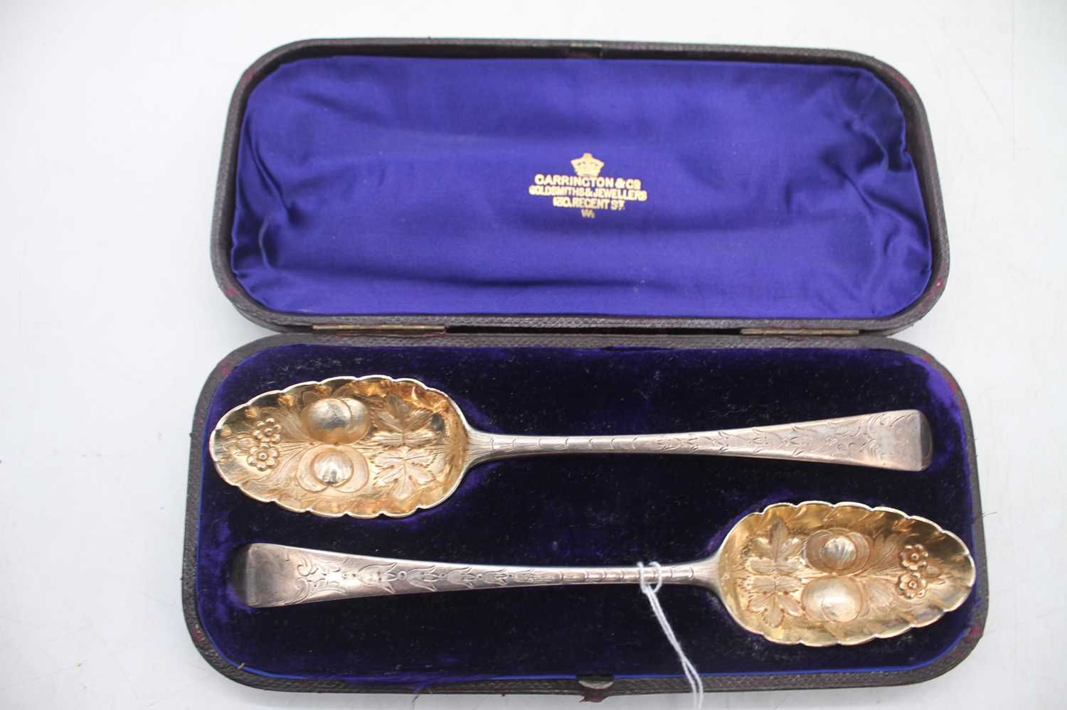 A pair of 19th century silver berry spoons, having embossed gilt washed bowls with bright cut