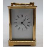 A 20th century lacquered brass cased carriage clock having an enamel dial with Roman numerals,