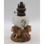 A Sitzendorf porcelain oil lamp, the basketweave font upon three lion supports, h.22cmThe shade