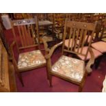 A pair of Arts & Crafts oak slat back carver chairs, having floral fabric upholstered drop-in pad