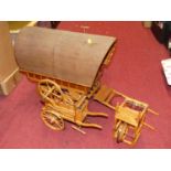A wooden and brass model of a gypsy caravan, together with various other wooden hand crafted models
