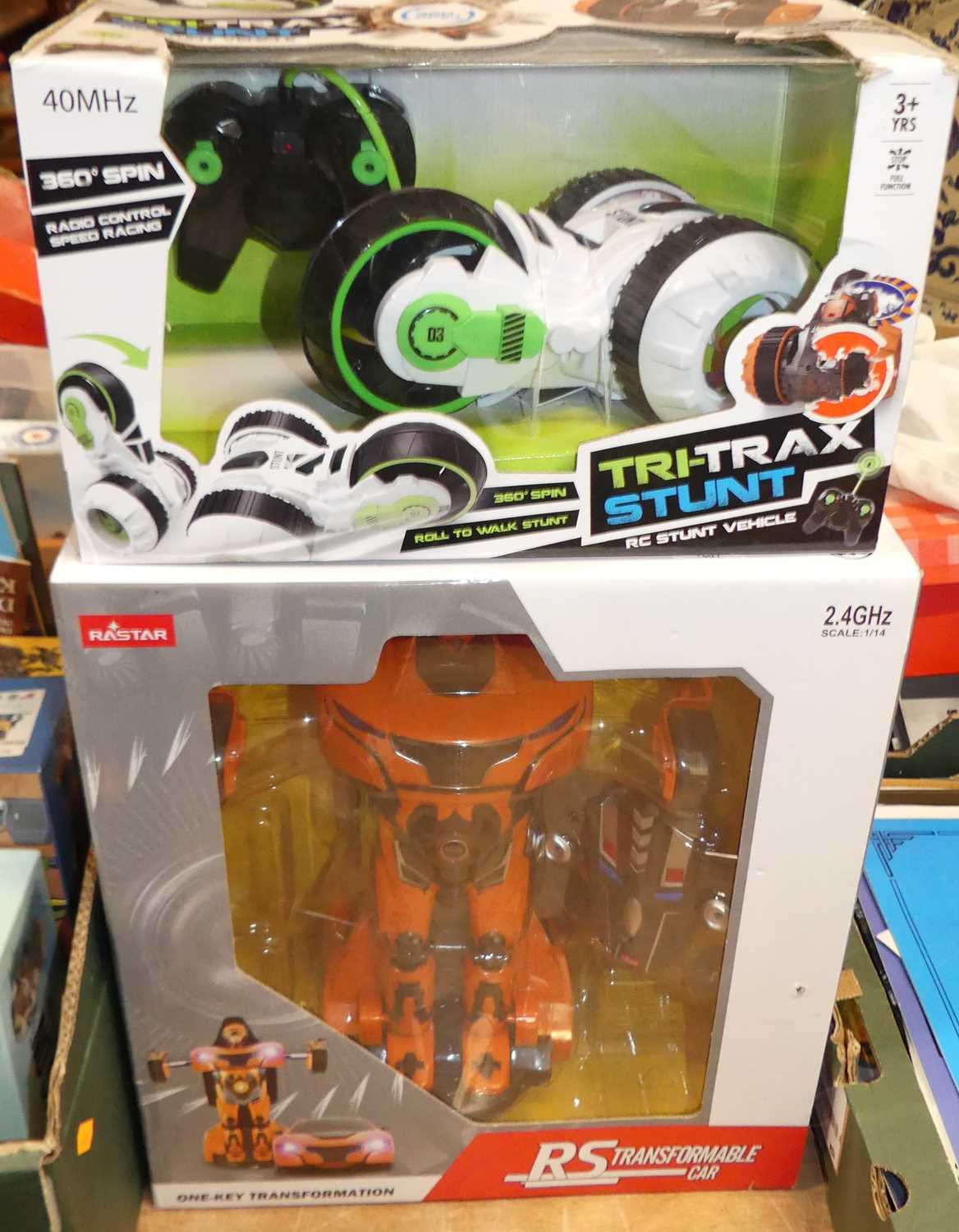 A radio controlled boxed toy group to include a Tri-Trax stunt bike together with a Rastar radio