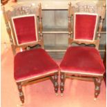 A set of six late Victorian carved walnut dining chairs having fabric upholstered pad backs and