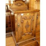 An early 20th century geometric moulded oak ledge back low single door bedside cupboard, width 43cm