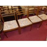 A set of four 1960s G-Plan teak ladder back dining chairs, having bright coloured fabric upholstered