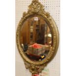 A circa 1900 gilt wood and gesso circular bevelled wall mirror, with floral crested surmount, 68 x