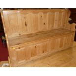 A contemporary pine six panel box seat settle having typical hinged compartment, width 143cm