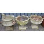 A pair of reconstituted stone pedestal garden urn planters, together with a further twin handled