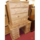 A modern pine kneehole dressing table, having two banks of four drawers, width 122cm, together