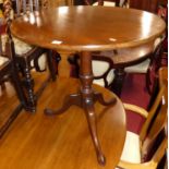 An early 19th century mahogany circular tilt top pedestal tripod table on hipped supports, dia.