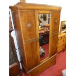 An early 20th century oak three-piece bedroom suite comprising; single bevelled mirror door wardrobe