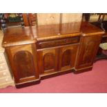 A Victorian mahogany round cornered inverted breakfront four door sideboard, having central frieze