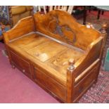 A contemporary stained hardwood two-seater settle with central hinged compartment, width 100cm