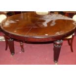 A Victorian mahogany extending circular dining table, raised on turned reeded and tapering