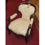 A mid-Victorian mahogany spoon back open armchair, having a carved and pierced floral crested top